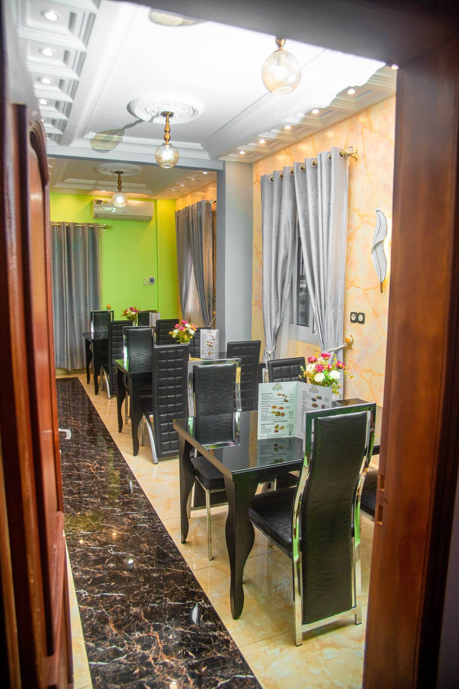 Restaurant dining room with black tables and marble floor